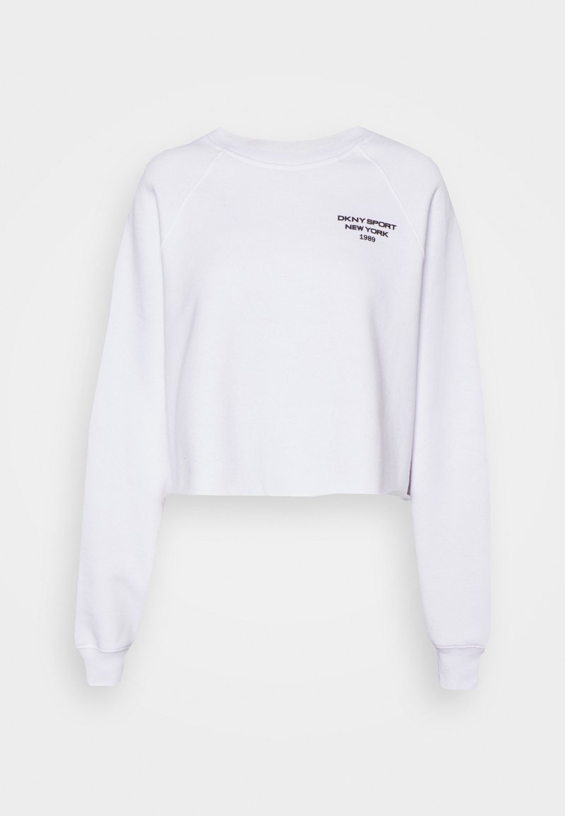 Sweat-shirt court blanc à manches longues, avec des poignets côtelés et un col rond. Présente un logo noir "DKNY SPORT NEW YORK 1989" imprimé à l'avant.