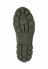 Green rubber shoe sole with deep treads and a textured surface. Features a circular pattern at the center and a size label (37).