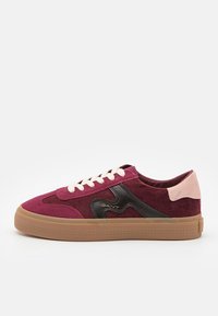 Baskets basses en daim rouge foncé et bordeaux avec lacets blancs, logo latéral noir, languette rose au talon et semelle en gomme.