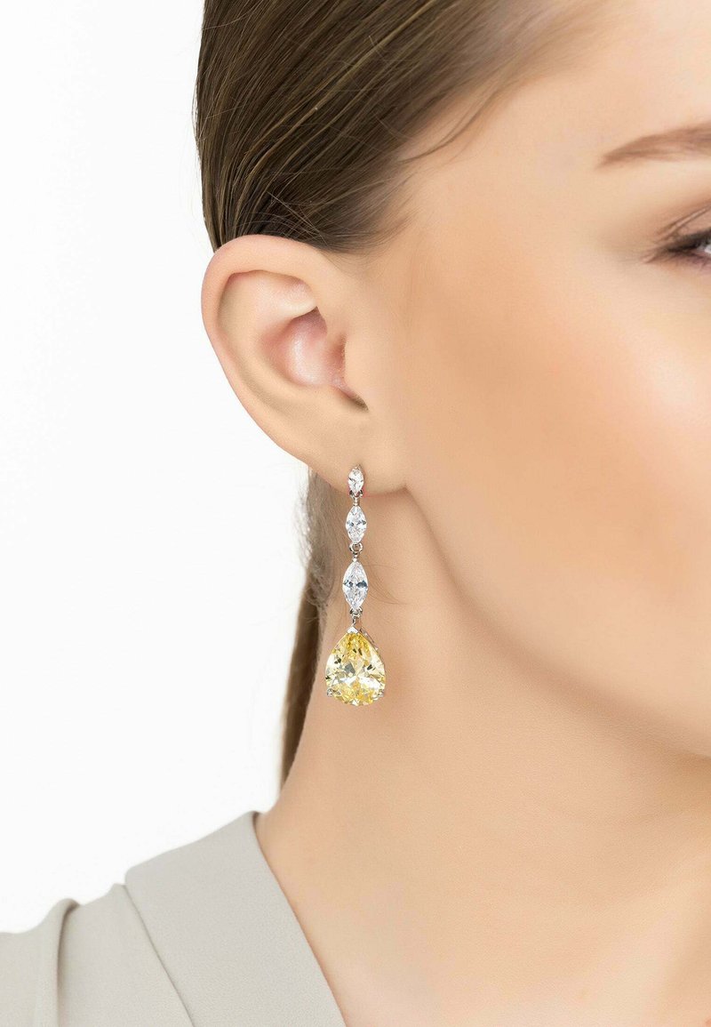Yellow and clear gemstone drop earrings with a silver setting; features a pear-shaped yellow stone and marquise-cut clear stones.