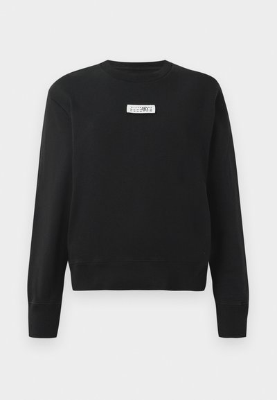 Černá mikina z bavlněné směsi s žebrovaným výstřihem a manžetami. Na hrudi se nachází obdélníková bílá nášivka s černým textem.