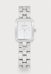 Silver rectangular watch with a polished metal bracelet and a white face. Features hour markers and a crystal-accented bezel. Brand: Guess.