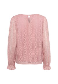 Light pink blouse with long sleeves, textured diamond patterns, and a keyhole back detail. Rounded cuffs with ruffled accents.