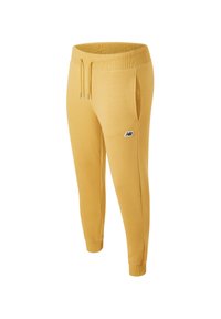 Yellow sweatpants made of soft fabric with a tapered design, elastic waistband, drawstring, and side pockets. Features a logo on the thigh.
