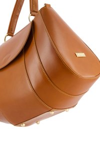 Braune Lederhandtasche mit strukturiertem Design, ausgestattet mit goldfarbenen Beschlägen und genoppten Akzenten am Boden. Glatte Textur und runde Form.
