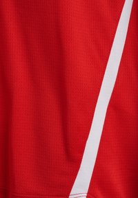 Tissu de sport rouge avec un motif texturé et une bande blanche diagonale sur le côté droit.