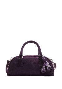 Lila Wildleder-Handtasche mit runder Form, ausgestattet mit einem Reißverschluss, zwei Griffen und dekorativen Nieten an einem Quastenakzent.