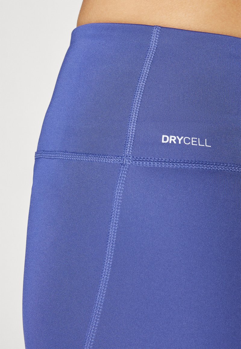 Lila Sportleggings mit glatter Textur, ausgestattet mit einem hohen Bund und kontrastierenden Nähten. Das „DRYCELL“-Logo befindet sich an der Seite.