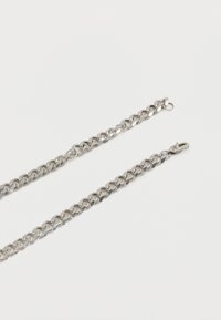 Ασημί μεταλλική αλυσίδα με επίπεδους συνδεδεμένους κρίκους και κούμπωμα καθαρού τύπου, πάνω σε λευκό φόντο.