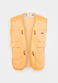 En orange väst med flera fickor, dragkedjor och bruna snoddar. Har tre horisontella randar på axlarna och en mjuk textur.