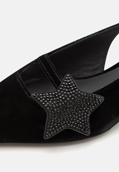 Black suede slingback shoe with star-shaped embellishment covered in black rhinestones. Features a minimalist design and open heel.
