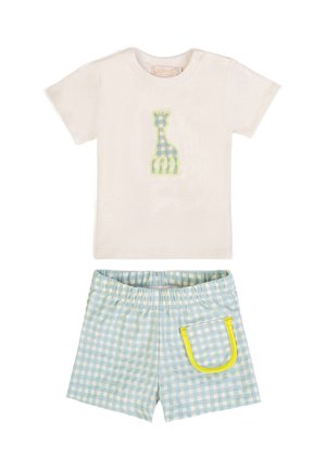 Maglietta crema per bambino con toppa a quadretti verde raffigurante una giraffa e pantaloncini a quadretti blu con tasca rifinita in giallo e vita elasticizzata.