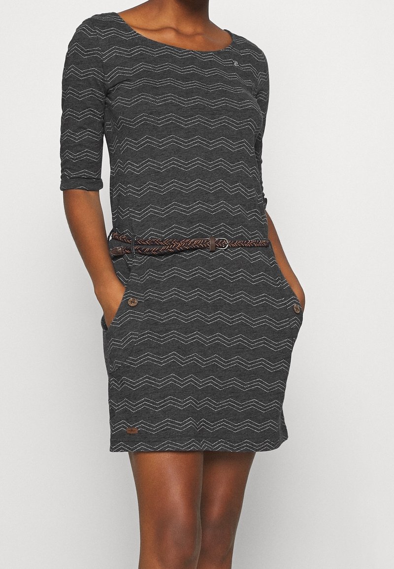 Vestido gris carbón con patrón en zigzag, de mangas tres cuartos, con dos bolsillos y un cinturón trenzado marrón; presenta detalles de botones.