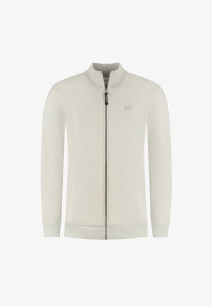 Light beige zip-up jacket with high collar, textured fabric, side pockets, and subtle branding on the chest. Ribbed cuffs and hem.