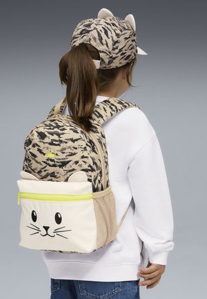 Mochila beige y negra con estampado y diseño de cara de gato, bolsillo lateral de malla y cremallera amarilla. Gorra ajustada con orejas de gato.