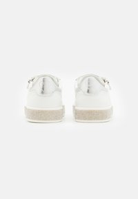 Sneakers bianche con tomaia in pelle liscia, dettagli in argento e suola impreziosita da strass luccicanti. Presentano un design a forma di cuore sul retro.