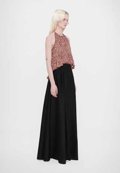 Haut sans manches en tissu à motifs roses et bruns, associé à une jupe noire longue, mettant en valeur une texture lisse et un design fluide.