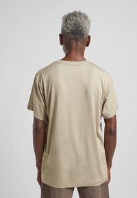 Beige Baumwoll-T-Shirt mit klassischem Rundhalsausschnitt und kurzen Ärmeln, mit einer glatten Textur und lockerer Passform.