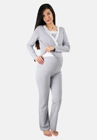Grauem Loungewear-Set mit einem Langarm-Oberteil mit Spitzenbesatz und passender Hose, beides aus weichem, dehnbarem Stoff.
