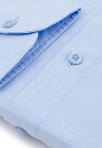 Jasnoniebieska koszula zapinana na guziki, wykonana z tkaniny o teksturowanym splocie, z wyraźnym kołnierzykiem, jednym widocznym guzikiem i precyzyjnym wykończeniem szwów.