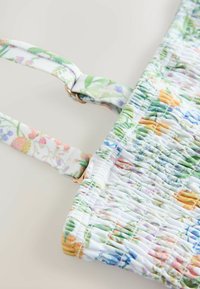 Top de estampado floral con textura fruncida en colores pastel. Presenta tirantes ajustables y detalles en dorado. Tela suave y elástica.