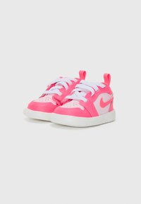 Children's sneakers featuring a bright pink synthetic upper, white laces, a white rubber sole, and a pull tab at the back for easy wear.