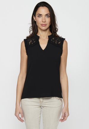 Musthave mustamata sleeveless top lõhenemist detaili ja V-kaelusega. Omab sileda tekstuuri ja lõdva istuvust, sobitades kergelt värviliste pükstega.