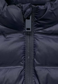 Námornícky prešívaný kabát s centrálnym zipsom, prešívanou textúrou a priliehavým golierom s flexibilným nastaviteľným uzáverom.