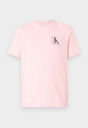 T-shirt à manches courtes rose clair avec petit logo "cK" de Calvin Klein imprimé sur le haut du côté gauche de la poitrine.
