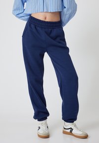 Donkerblauwe sweatpants van een katoenmix met een elastische tailleband en cuffed enkels. Voorzien van zijzakken en een relaxte pasvorm.