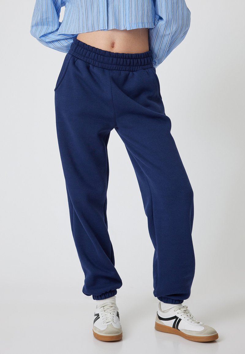 Donkerblauwe sweatpants van een katoenmix met een elastische tailleband en cuffed enkels. Voorzien van zijzakken en een relaxte pasvorm.