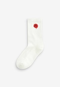 Calze bianche a coste con un piccolo ricamo di faccina sorridente rossa vicino al risvolto. Realizzate in tessuto morbido, progettate per il comfort e l'abbigliamento informale.