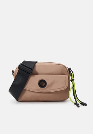 Beige Umhängetasche mit schwarzem verstellbarem Riemen, Vordertasche mit schwarzem runden Detail und grün-schwarzem Kordelreißverschluss.