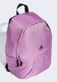 Zaino in nylon viola con dettagli neri e tasca frontale con zip. Presenta una maniglia superiore e spallacci regolabili. Logo Adidas sul lato.