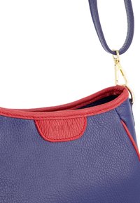 Lila Leder Tasche mit roten Akzenten, featuring eine glatte Textur und einem goldenen Hardware-Verschluss. Logo auf dem roten Abschnitt geprägt.