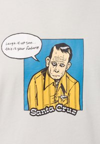 Witte katoenen t-shirt met een grafische illustratie van een man in een geel shirt tegen een blauwe achtergrond. Een tekstballon zegt: "Lach maar, zoon... dit is jouw toekomst."