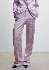 Lavender satin suit with polka dot pattern, featuring a tailored blazer and wide-leg trousers, finished with pointed black shoes.