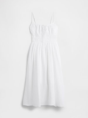 Robe midi blanche avec des fines bretelles, taille froncée, buste froncé et jupe ample texturée.
