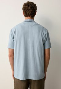 Kurzärmliges, blaues Button-up-Hemd mit strukturiertem Muster, ausgestattet mit einem Kentkragen und geradem Saum.