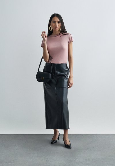 Jasnoróżowa obcisła koszulka, czarna skórzana spódnica midi, czarna torebka ze złotymi detalami, czarne szpilki z ostrym noskiem, czyste tło.