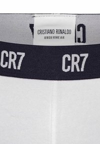 Weiße Unterwäsche mit einem grauen elastischen Bund, auf dem "CR7" in weißen Buchstaben steht. Der Stoff wirkt glatt und eng anliegend. Markenlabel sichtbar.