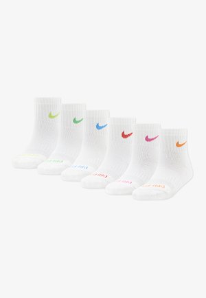 Six paires de chaussettes blanches à la cheville alignées, chacune arborant un swoosh Nike de couleur différente et le texte « DRI-FIT » assorti sur les orteils.