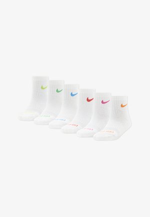 Six paires de chaussettes blanches à la cheville alignées, chacune arborant un swoosh Nike de couleur différente et le texte « DRI-FIT » assorti sur les orteils.