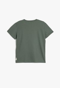 T-shirt a maniche corte, collo rotondo, in verde oliva, con tessuto testurizzato. Presenta un piccolo etichetta sull'orlo e una vestibilità rilassata.