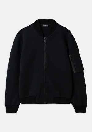 Chaqueta bomber negra con cremallera, cuello y puños acanalados, que cuenta con un bolsillo con cremallera en la manga y una textura suave.