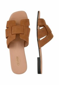 Brązowe zamszowe klapki wsuwane z szerokimi paskami i płaską czarną gumową podeszwą. Posiadają gładką wkładkę i minimalistyczny design.