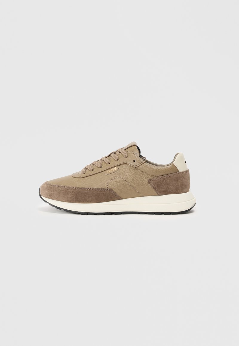 Beige sneakers med rund tå, laget av lær og semsket skinn, snøring, gummisåle og subtil logo-detalj på siden.
