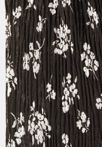 Material negru cu imprimeu floral alb și pliuri verticale dintr-un material ușor, texturat și moale.