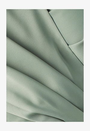 Hele roheline kangas, millel on sile, mati tekstuur, pehmed voldid ja langevad osad. Ei ole nähtavaid mustreid ega riistvara detaile.