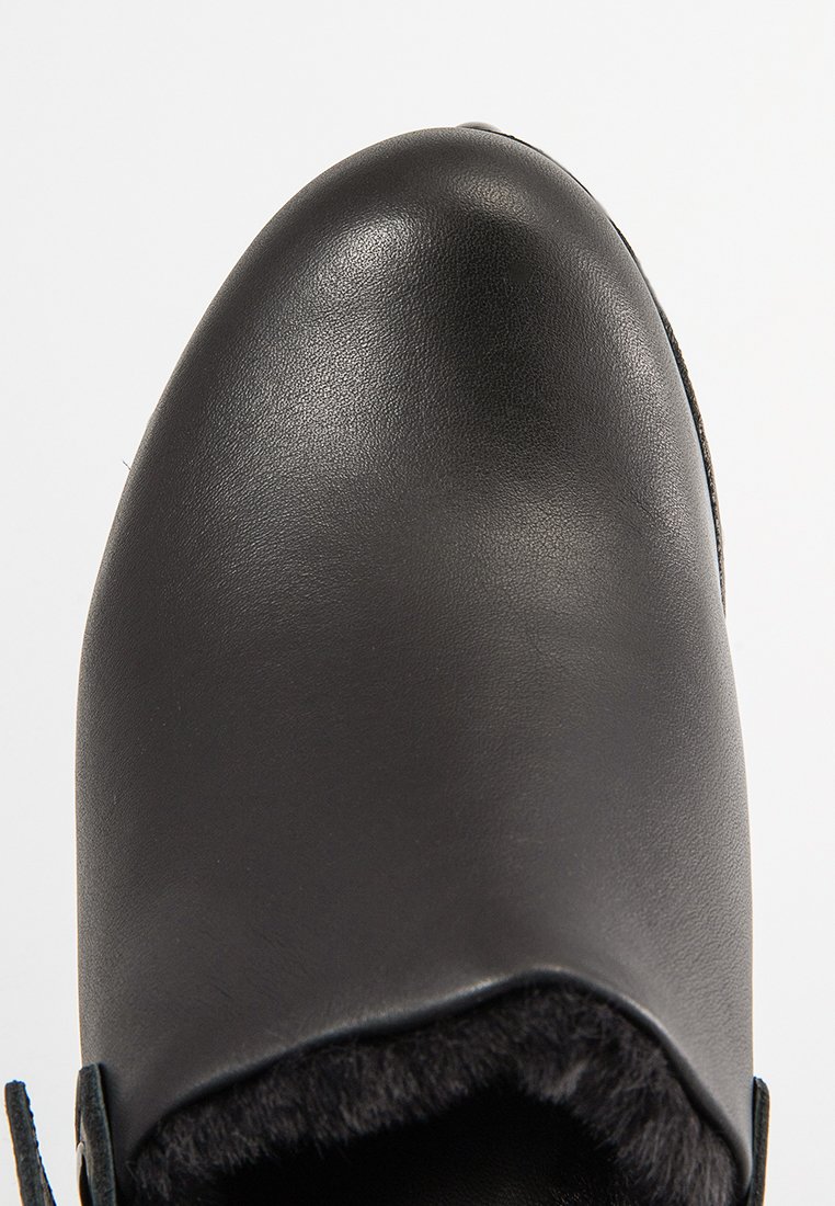 Schwarze Lederschuhe mit glatter, glänzender Oberfläche und runder Spitze. Innen mit weichem Fell gefüttert für zusätzlichen Komfort. Minimalistisches Design.